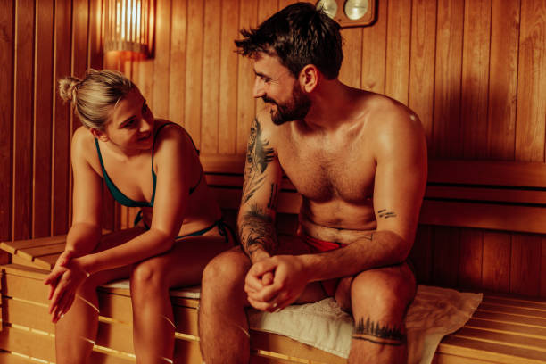 Beautiful couple in swimwear relaxing in sauna and caring about health and skin